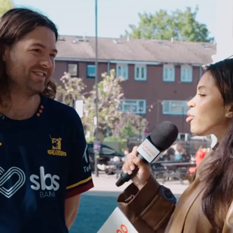 Two people talking into a microphone at an outdoor event